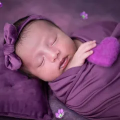 A close-up shot to capture the tiniest details, from her soft cheeks to her little mouth. Holding a small felted heart adds an extra touch of sweetness to this newborn portrait.