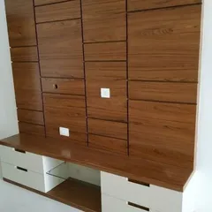 This TV unit features a unique textured wood panel design with concealed storage. The lower console has white drawers and open shelves for media devices.