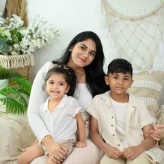 A sweet moment between a mother and her two children. The natural, light-filled studio setting provides a perfect backdrop for these candid family photos.