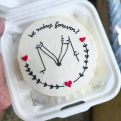 A simple question on a minimalist bento cake can make for the sweetest moment. This design features clean, hand-piped line art of a couple holding hands, perfect for anniversaries, proposals, or just because.