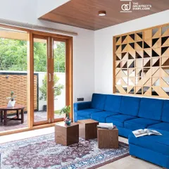 Another view of the Cube House living room, showing how the indoor space flows into an outdoor seating area, visually connected by the continuity of the wooden design elements.