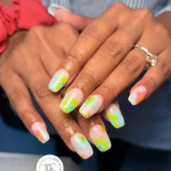 A fun, abstract watercolor-style manicure. This design uses splashes of bright neon colors over a milky white base to create a vibrant, artistic look perfect for summer.