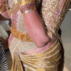 A close-up of the side pleats on a heavily embellished gold saree. Even with thick fabric and sequins, I ensure the pleats are neat, flat, and securely tucked in.