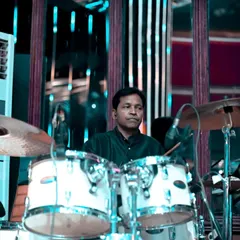 Another shot of our drummer, focused and in the zone. The drum kit is essential for driving the energy during our live fusion performances.