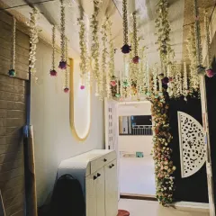 An elegant entryway decoration with hanging strings of jasmine and roses. This design creates a beautiful floral ceiling that makes the passage feel special and festive.