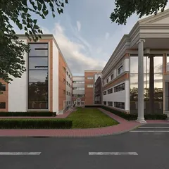 A perspective of the school building, showing the relationship between the classical main entrance and the more modern adjoining wings. The design balances tradition with contemporary needs.