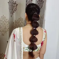A soft bubble braid wrapped with delicate pearls. This modern and playful style is perfect for a sangeet or cocktail party.