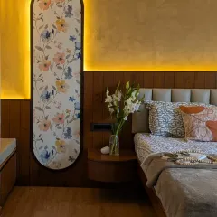 This master bedroom features a custom floral panel with backlight, creating a soft, artistic glow behind the bed.