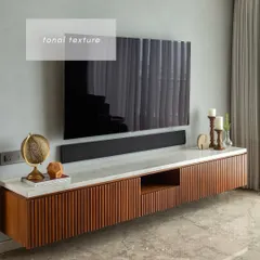 The TV unit in this home is a study in tonal texture. We designed a floating console with fluted wood details and a marble top, set against a grey textured wall, creating a look that is both modern and sophisticated.