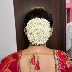 The beauty of fresh mallige flowers. Here, they are perfectly wrapped around a classic bun, creating a fragrant and timelessly elegant hairstyle for a traditional South Indian look.