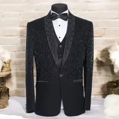 This is a full view of my black sequined tuxedo on a mannequin. The design shows a gradient of beadwork from the shoulder down, creating a sparkling texture that catches the light, perfect for a gala or stage performance.