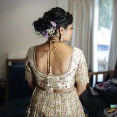 A close-up of a messy, textured bun for a sunset wedding. I incorporated delicate baby's breath and other small flowers for a soft, romantic touch.