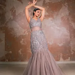 This pose showcases the full silhouette of the mermaid gown. The model's arms create a beautiful frame, drawing attention to the intricate beadwork and the elegant fall of the tulle skirt.