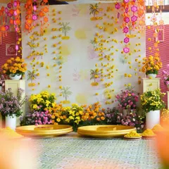 The main seating area for the Haldi, featuring a backdrop of falling marigolds and traditional umbrellas. This setup provided a beautiful and auspicious spot for the couple's ceremony.
