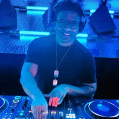 In my element, behind the decks. My job is to read the room and play the tracks that keep everyone moving. This shot captures me during a live set, focused on the music and the dance floor.