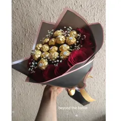 A classic romantic gift: a beautiful bouquet of fresh red roses and Ferrero Rocher chocolates, all hand-tied and wrapped.