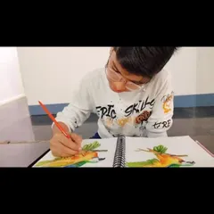 A young artist completely absorbed in his watercolor painting, showcasing the focus that art inspires.