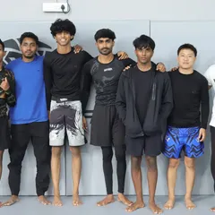 One of the talented teams that competed in our annual in-house Jiu-Jitsu tournament, standing proud with their coach.