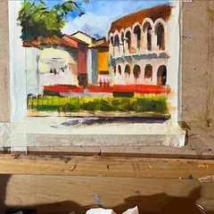 The painting of Verona in progress on my easel. This shows the initial layers and color blocking as I build the composition.