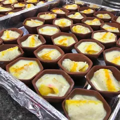 I offer several varieties of sweets served in earthen pots (matkas). This tray shows another popular option, a creamy dessert with a sweet yellow topping, ready to be served at a celebration.