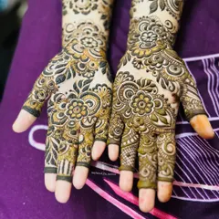 A close-up of the hands from the 'baat pakki' design, showing the intricate floral patterns on the palms and fingers.