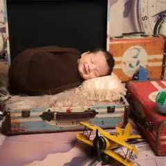 This little traveler is dreaming of adventures. Using vintage suitcases, globes, and toy planes, I created a whimsical travel-themed set for this sleeping newborn.