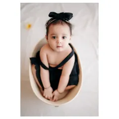 A beautiful, simple portrait of a baby girl in a basket. The overhead angle and her direct gaze create a captivating and intimate photo.