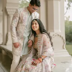 A quiet moment of affection on a palace veranda. The intricate floral outfits of the couple blend beautifully with the regal setting, showcasing a soft, pastel-themed pre-wedding shoot.