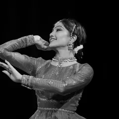 A black and white portrait capturing a moment of shringara, or romantic love, from a performance. The expressive power of the face and eyes is central to Indian classical dance.