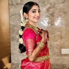 A beautiful South Indian bride showcasing her traditional hairstyle. I created a long, decorated braid adorned with fresh jasmine flowers (veni) and temple-style hair accessories, a hallmark of the classic South Indian bridal look.