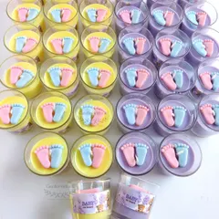 A colorful array of baby feet votive candles in lilac and yellow, made for a teddy bear themed baby shower. Each one is ready for its personalized sticker.