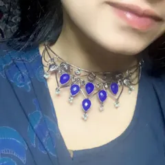 A closer look at this blue choker set, featuring a delicate black polish chain and deep blue stones. It's a versatile piece that can be dressed up or down.