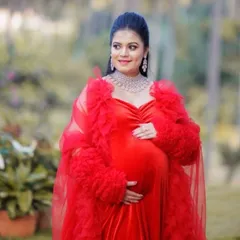 A truly regal look for a mom-to-be. This combination of a red velvet gown and a dramatic ruffled tulle robe creates a luxurious and high-fashion maternity portrait.