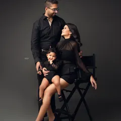 Squad goals! This family portrait is all about modern style and fun. The coordinated black outfits and the little one's happy expression make for a stunning and memorable family photo.