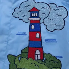 This is a close-up of a lighthouse embroidery from a boat-themed saya kurta I made for a child's first birthday.