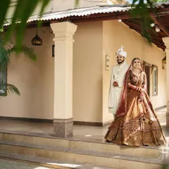 A classic wedding day portrait. The couple stands together, perfectly framed, marking the beginning of their new life. This is a timeless shot that captures the elegance and significance of the day.