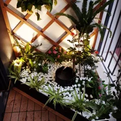 This compact corner garden is built around a small, bubbling water fountain. The sound of water, combined with lush plants and a bed of white pebbles, transforms a forgotten corner into a point of interest.