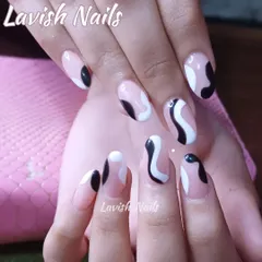 A modern, abstract design with black and white organic shapes on a neutral base. This hand-painted art gives a minimalist, artistic vibe to these oval-shaped nails.