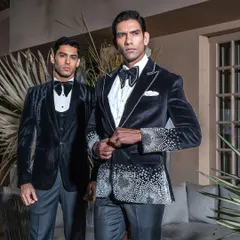 We craft wedding tuxedos that are designed to be as memorable as the occasion itself. This image showcases two of our signature velvet tuxedos, featuring intricate crystal work and a modern silhouette, perfect for the groom who seeks distinction and elegance.