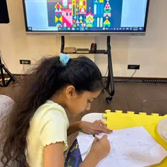 The first step is sketching out the concept. Here, a student plans her Mary Blair inspired castle, thinking about how to combine different geometric shapes.