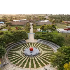 An aerial view of the stone amphitheater at the H.N. Science Center, a space designed for community gathering and learning. The design integrates with the landscape, using local stone and grass to create a functional yet organic public space.