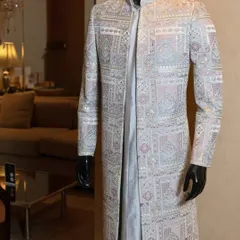 This sherwani showcases decades of craft in a single silhouette. The intricate, geometric embroidery in delicate pastel hues creates a look of understated grandeur, perfect for a sophisticated day wedding.