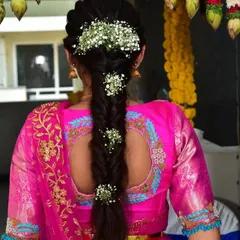 This image highlights a beautiful keyhole back design on a bright pink blouse. The embroidery follows the cut of the neckline, and the fishtail braid hairstyle allows the blouse detail to be the star.