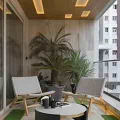 A modern and minimalist balcony design with comfortable seating and subtle floor lighting. The recessed ceiling lights add a sophisticated ambiance for evening use.