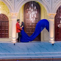 A grand, architectural setting provides the perfect backdrop for this couple's portrait, with the royal blue gown creating a striking visual against the neutral tones.
