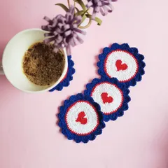 Our heart coasters in use, placed under a coffee mug. They are made from absorbent cotton yarn to protect your surfaces from drips and heat.