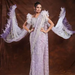 A dramatic full-length shot of a lavender saree with feathered sleeves. The pose is designed to show off the unique silhouette and intricate details of the garment.