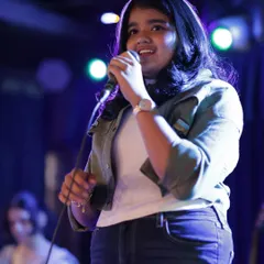Confidence on stage is key. Here, one of our vocal students commands the microphone at our annual show. Our vocal coaching and ensemble practice build the skills to sing out loud and proud.