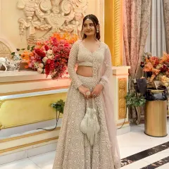 You don’t have to buy a lehenga to feel like it’s made for you. This client looks stunning in a full-length shot of the beige lehenga, complete with a matching potli bag.