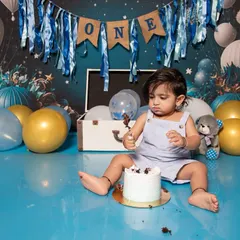 Exploring the textures and tastes of a birthday cake is a big adventure for a one-year-old. This shot captures his focus and determination during his fun and messy cake smash photoshoot.